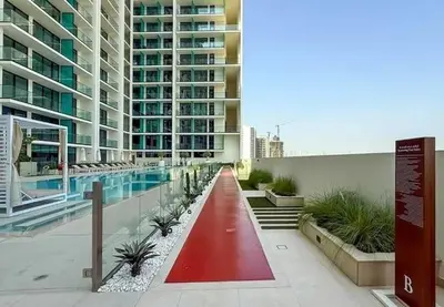a large building with a swimming pool in front of it at 15 min from Dubai Marina & JBR beach Studio apartment AZURE BINGHATTI JVC in Dubai