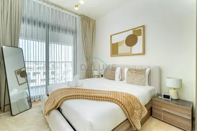 a bedroom with a large bed and a large window at Located Near Community Parks, Convenient Stores, an RTA Bus Stop, And Just Minutes From The Mall - Binghatti Emerald, JVC by Deluxe Holiday Homes in Dubai