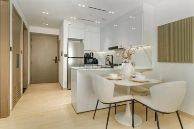 a kitchen and dining room with a table and chairs at Located Near Community Parks, Convenient Stores, an RTA Bus Stop, And Just Minutes From The Mall - Binghatti Emerald, JVC by Deluxe Holiday Homes in Dubai