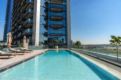 a swimming pool in front of a tall building at City Living with Street Views, Just a Walk to Bus Stop, Easy Transport to Burj Khalifa and Dubai Mall, Nobles Tower, Business Bay by Deluxe Holiday Homes in Dubai
