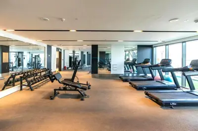 a gym with rows of treadmills and exercise bikes at City Living with Street Views, Just a Walk to Bus Stop, Easy Transport to Burj Khalifa and Dubai Mall, Nobles Tower, Business Bay by Deluxe Holiday Homes in Dubai