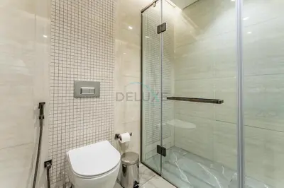 a bathroom with a toilet and a glass shower at City Living with Street Views, Just a Walk to Bus Stop, Easy Transport to Burj Khalifa and Dubai Mall, Nobles Tower, Business Bay by Deluxe Holiday Homes in Dubai
