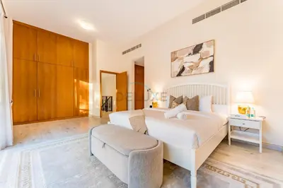 a bedroom with a large white bed and a couch at 4BR plus Maids Room Villa Near Nad Al Sheba Mall, With Easy Access to Major Dubai Attractions - Nad Al Shiba Third, Nad Al Sheba by Deluxe Holiday Homes in Dubai