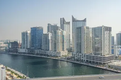 a city with a river and tall buildings at Dubai Water Canal View, Minutes away from Burj Khalifa and Dubai Mall, Near Metro Bus Station - Prive by Damac B, Business Bay by Deluxe Holiday Homes in Dubai