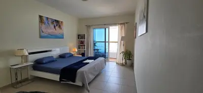 a bedroom with a blue bed and a view of the ocean at Elite Residence, Marina in Dubai