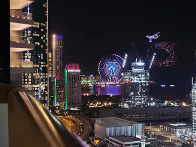 a city skyline at night with a ferris wheel at Elite Residence, Marina in Dubai
