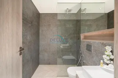 a bathroom with a shower and a toilet and a sink at Few Minutes Walk to Circle Mall, Conveniently Close Community Park, and Near the Bus Station for Effortless Metro Access - Oxford Terraces, JVC by Deluxe Holiday Homes in Dubai