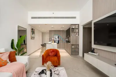 a living room with a couch and a table at Few Minutes Walk to Circle Mall, Conveniently Close Community Park, and Near the Bus Station for Effortless Metro Access - Oxford Terraces, JVC by Deluxe Holiday Homes in Dubai