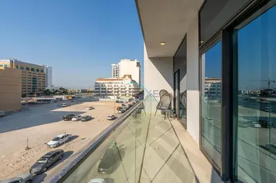 a balcony of a building with a view of a parking lot at Few Minutes Walk to Circle Mall, Conveniently Close Community Park, and Near the Bus Station for Effortless Metro Access - Oxford Terraces, JVC by Deluxe Holiday Homes in Dubai