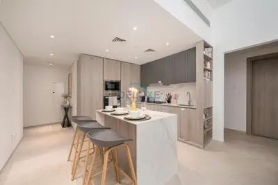 a kitchen with a island with bar stools at Few Minutes Walk to Circle Mall, Conveniently Close Community Park, and Near the Bus Station for Effortless Metro Access - Oxford Terraces, JVC by Deluxe Holiday Homes in Dubai