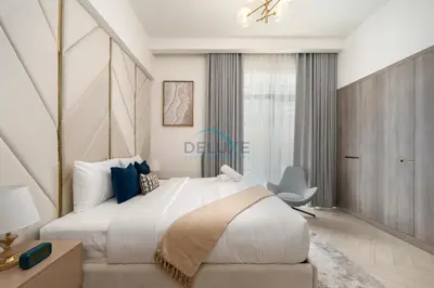 a bedroom with a large white bed and a window at Few Minutes Walk to Circle Mall, Conveniently Close Community Park, and Near the Bus Station for Effortless Metro Access - Oxford Terraces, JVC by Deluxe Holiday Homes in Dubai
