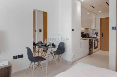 a kitchen and dining room with a table and chairs at High-Floor Studio Overlooking the Community, Just a Short Drive to Miracle Garden, Binghatti Azure, JVC by Deluxe Holiday Homes in Dubai