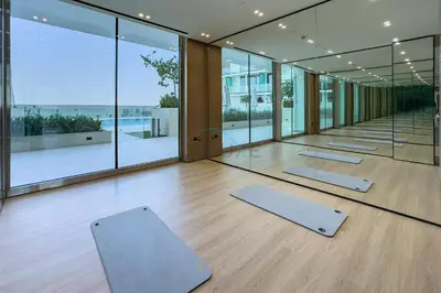 a row of yoga mats in a room with windows at High-Floor Studio Overlooking the Community, Just a Short Drive to Miracle Garden, Binghatti Azure, JVC by Deluxe Holiday Homes in Dubai