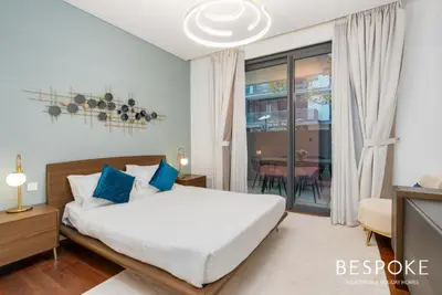 a bedroom with a bed with blue pillows at Bespoke Holiday Homes - 2BR plus Kids room in City Walk with Direct Pool Access in Dubai
