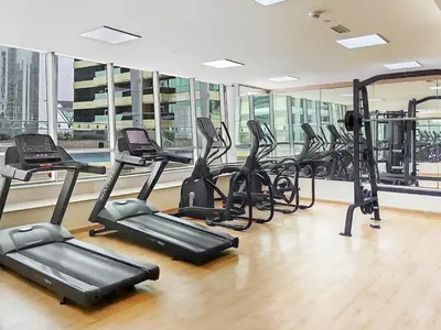 a gym with a bunch of exercise bikes in a room at Modern 1BR by the Lake Near DMCC Metro Station in Dubai