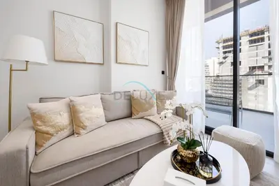 a living room with a couch and a table at Close to Community Park, Minutes Walk from Circle Mall, and Short Drive to Dubai Miracle Garden and Butterfly Garden - Binghatti Amber, JVC by Deluxe Holiday Homes in Dubai