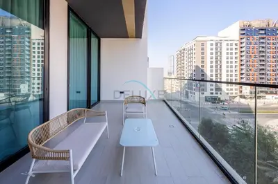 a balcony with two chairs and a white bench on it at Close to Community Park, Minutes Walk from Circle Mall, and Short Drive to Dubai Miracle Garden and Butterfly Garden - Binghatti Amber, JVC by Deluxe Holiday Homes in Dubai