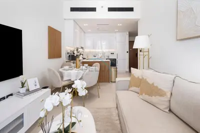 a living room with a couch and a dining room at Close to Community Park, Minutes Walk from Circle Mall, and Short Drive to Dubai Miracle Garden and Butterfly Garden - Binghatti Amber, JVC by Deluxe Holiday Homes in Dubai