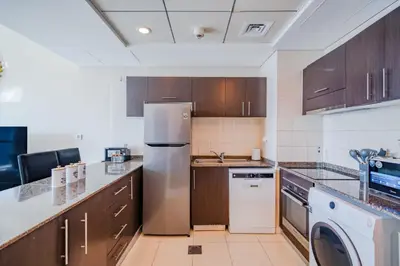 a kitchen with a refrigerator and a dishwasher at Spacious 1BHK Apt with Canal View in Dubai Marina in Dubai