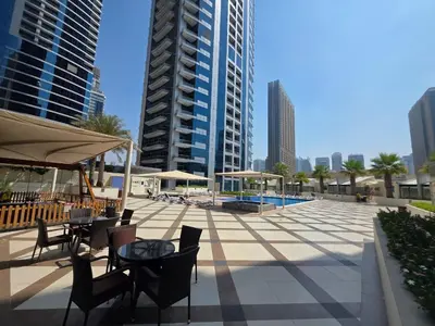 a patio with tables and chairs and buildings at Spacious 1BHK Apt with Canal View in Dubai Marina in Dubai