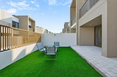 a patio with chairs and green grass on a building at Golden Stays - Luxe 4BR Villa Family-Friendly and Fully Equipped in Dubai