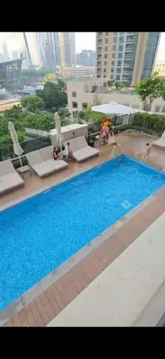 a large swimming pool in a building with chairs at Act Tower 410 in Dubai