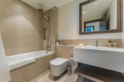 a bathroom with a toilet and a tub and a sink at Direct Private Beach Access, Proximity To Key Dubai Attractions Like Dubai Marina, Palm Jumeirah, And JBR Walk - Palace Beach Residence Tower 2, Emmar Beachfront by Deluxe Holiday Homes in Dubai