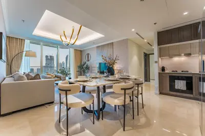 a dining room and living room with a table and chairs at Direct Private Beach Access, Proximity To Key Dubai Attractions Like Dubai Marina, Palm Jumeirah, And JBR Walk - Palace Beach Residence Tower 2, Emmar Beachfront by Deluxe Holiday Homes in Dubai