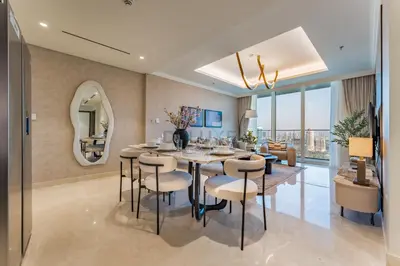 a dining room and living room with a table and chairs at Direct Private Beach Access, Proximity To Key Dubai Attractions Like Dubai Marina, Palm Jumeirah, And JBR Walk - Palace Beach Residence Tower 2, Emmar Beachfront by Deluxe Holiday Homes in Dubai