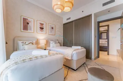 a bedroom with two beds and a couch at Prestigious Waterfront Community, Beachfront Living Near Dubai Marina and Top Dining Hotspots - Palace Beach Residence Tower 2, Emaar Beachfront by Deluxe Holiday Homes in Dubai