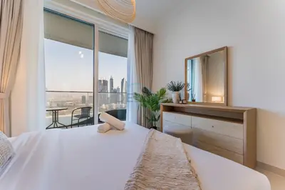 a bedroom with a large bed and a large window at Prestigious Waterfront Community, Beachfront Living Near Dubai Marina and Top Dining Hotspots - Palace Beach Residence Tower 2, Emaar Beachfront by Deluxe Holiday Homes in Dubai