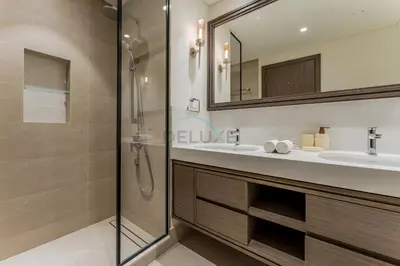 a bathroom with a shower and a sink and a mirror at Prestigious Waterfront Community, Beachfront Living Near Dubai Marina and Top Dining Hotspots - Palace Beach Residence Tower 2, Emaar Beachfront by Deluxe Holiday Homes in Dubai