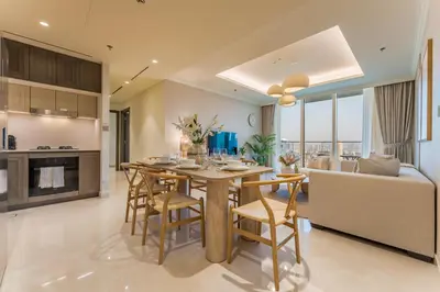 a kitchen and living room with a table and chairs at Prestigious Waterfront Community, Beachfront Living Near Dubai Marina and Top Dining Hotspots - Palace Beach Residence Tower 2, Emaar Beachfront by Deluxe Holiday Homes in Dubai