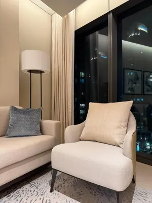 a living room with a couch and a chair and a window at Address Opera in Dubai