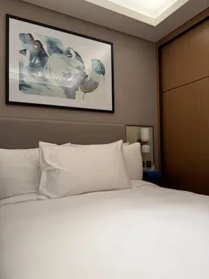a bedroom with a white bed with a picture on the wall at Address Opera in Dubai