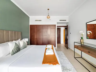 a bedroom with a large white bed and a television at Serene 1BDR Unit -Burj Views, Downtown in Dubai