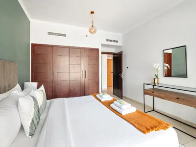 a bedroom with a white bed with a wooden headboard at Serene 1BDR Unit -Burj Views, Downtown in Dubai