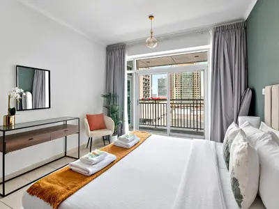 a bedroom with a large white bed and a desk at Serene 1BDR Unit -Burj Views, Downtown in Dubai