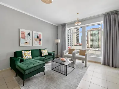 a living room with a green couch and a table at Serene 1BDR Unit -Burj Views, Downtown in Dubai