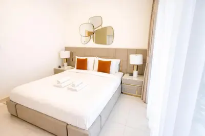 a bedroom with a large white bed and a mirror at Burj Khalifa View 2BR Luxury Apartment in Dubai in Dubai