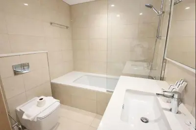 a bathroom with a tub and a toilet and a sink at Burj Khalifa View 2BR Luxury Apartment in Dubai in Dubai