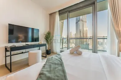 a bedroom with a large white bed and a large window at High Floor with Direct Burj Khalifa and Fountain Views, Just Steps from Dubai Mall and Metro Station - Burj Vista Tower 1, Downtown Dubai by Deluxe Holiday Homes in Dubai