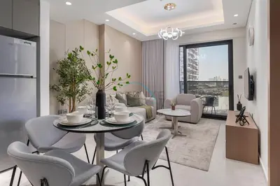 a kitchen and living room with a table and chairs at Modern 1BR Haven Near the Park, Offering Effortless Connectivity to Key Roads, Cloud A, Jumeirah Village Triangle by Deluxe Holiday Homes in Dubai