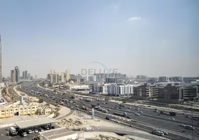a freeway with traffic in a city with buildings at Modern 1BR Haven Near the Park, Offering Effortless Connectivity to Key Roads, Cloud A, Jumeirah Village Triangle by Deluxe Holiday Homes in Dubai
