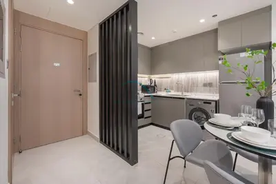 a kitchen and dining room with a table and chairs at Modern 1BR Haven Near the Park, Offering Effortless Connectivity to Key Roads, Cloud A, Jumeirah Village Triangle by Deluxe Holiday Homes in Dubai