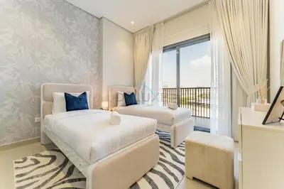 two beds in a room with a balcony at Walking Distance to Miracle Garden and Butterfly Garden, 20 Minutes Drive to Dubai Marina and Palm Jumeirah - Divine Living, Arjan, by Deluxe Holiday Homes in Dubai