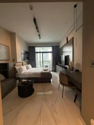 a hotel room with a bed and a desk and a desk at Furnished Studio 2 min Walk to Burji Khalifa in Dubai