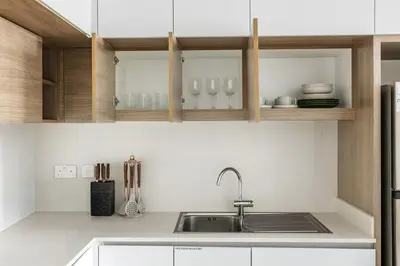 a kitchen with a sink and wooden cabinets at Luxurious 1BR Modern Apartment Balcony Pool in Dubai