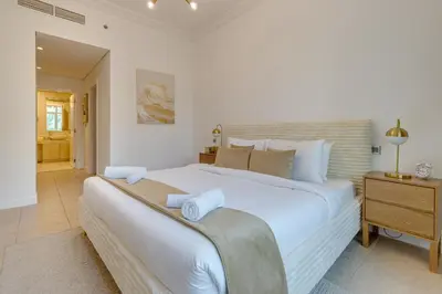 a large white bedroom with a large white bed at Al Sarrood, Palm Jumeirah - 1 Bedroom Apartment - Allsopp & Allsopp in Dubai