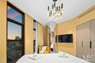 a bedroom with a bed and a large window at Luxury High Floor 1BHK Burj and Canal Views in Dubai